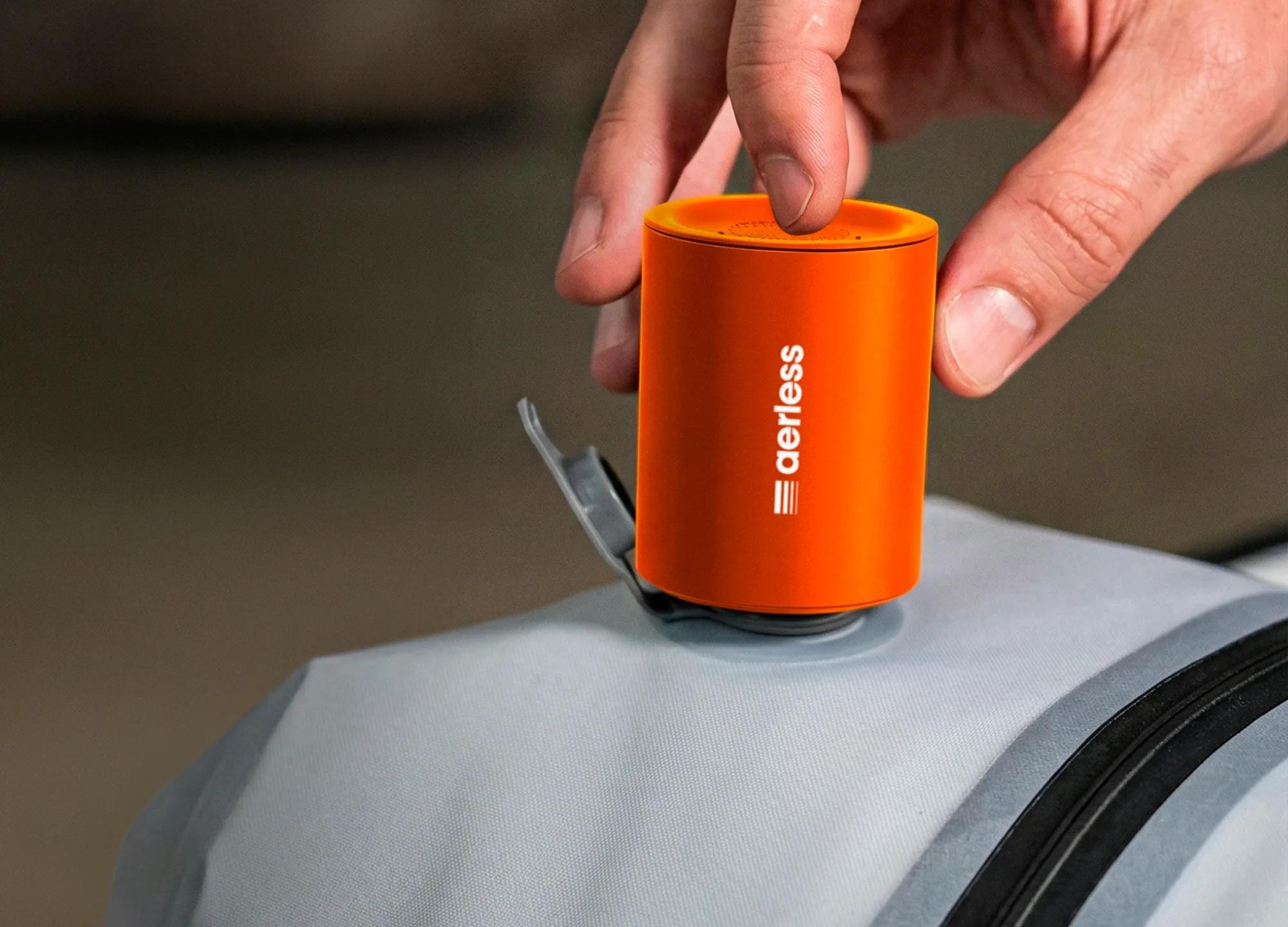 Placing the orange Aerless device onto a gray compression bag