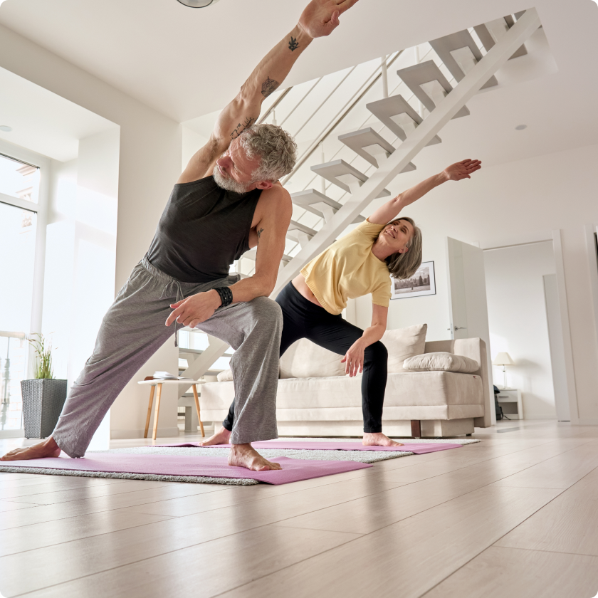 A couple doing a stretching routine at home, the kind of regular movement liver-health research supports