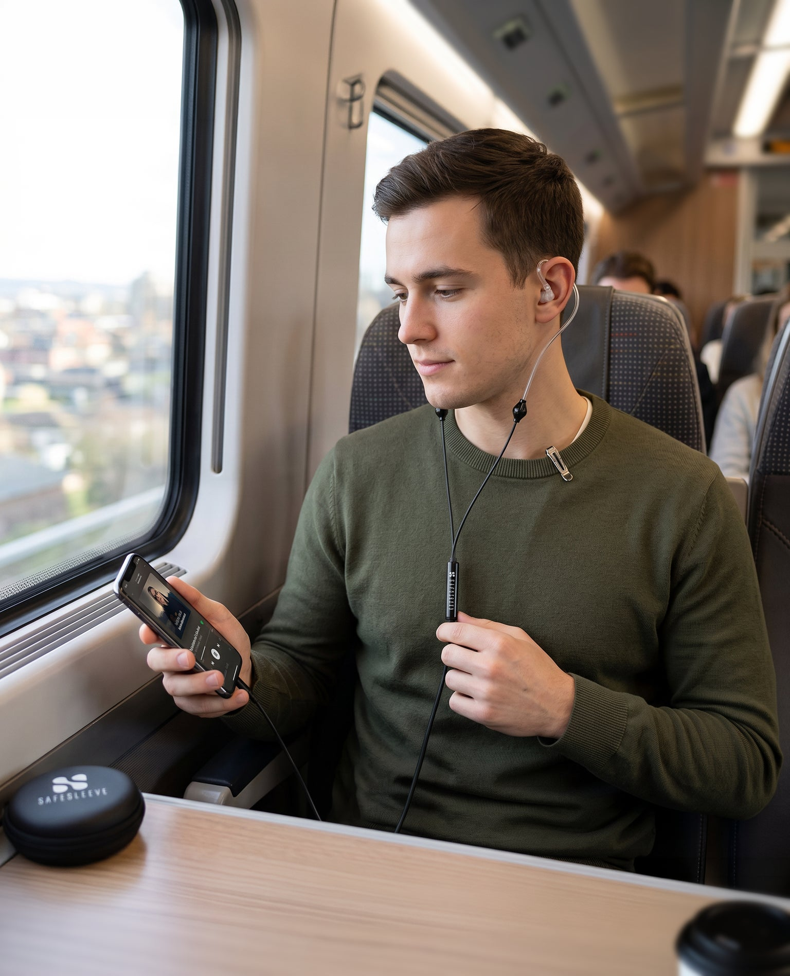 Man using SafeSleeve earphones on a train