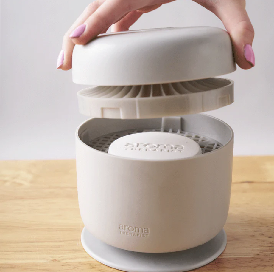 Close-up of AromaAmplifier lid being lifted to reveal aroma pod