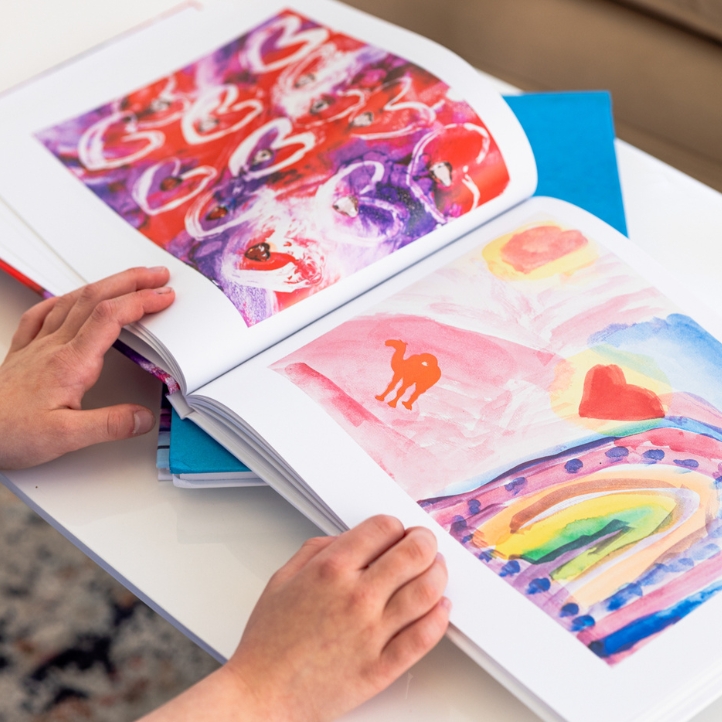Close-up of hands turning pages of a finished Artkive book