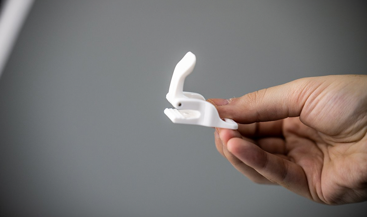 Person tightening the Bed Scrunchie cord under a mattress