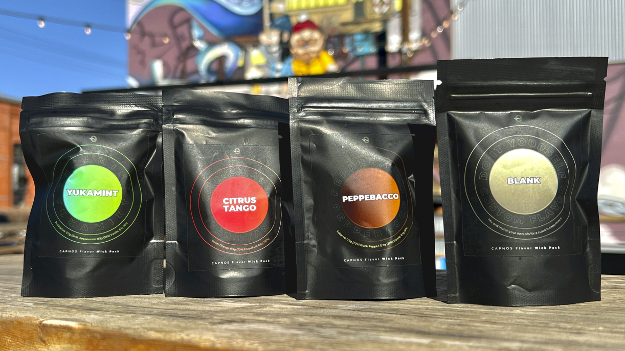 Four Capnos flavor pouches displayed outdoors