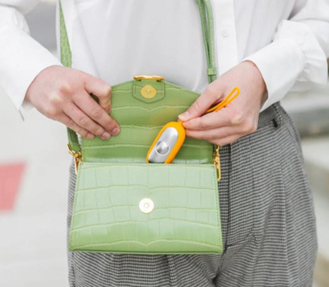 Person placing the Chill Pill device into a purse