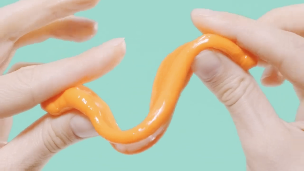 Close-up of hands stretching a softened orange FixIts stick