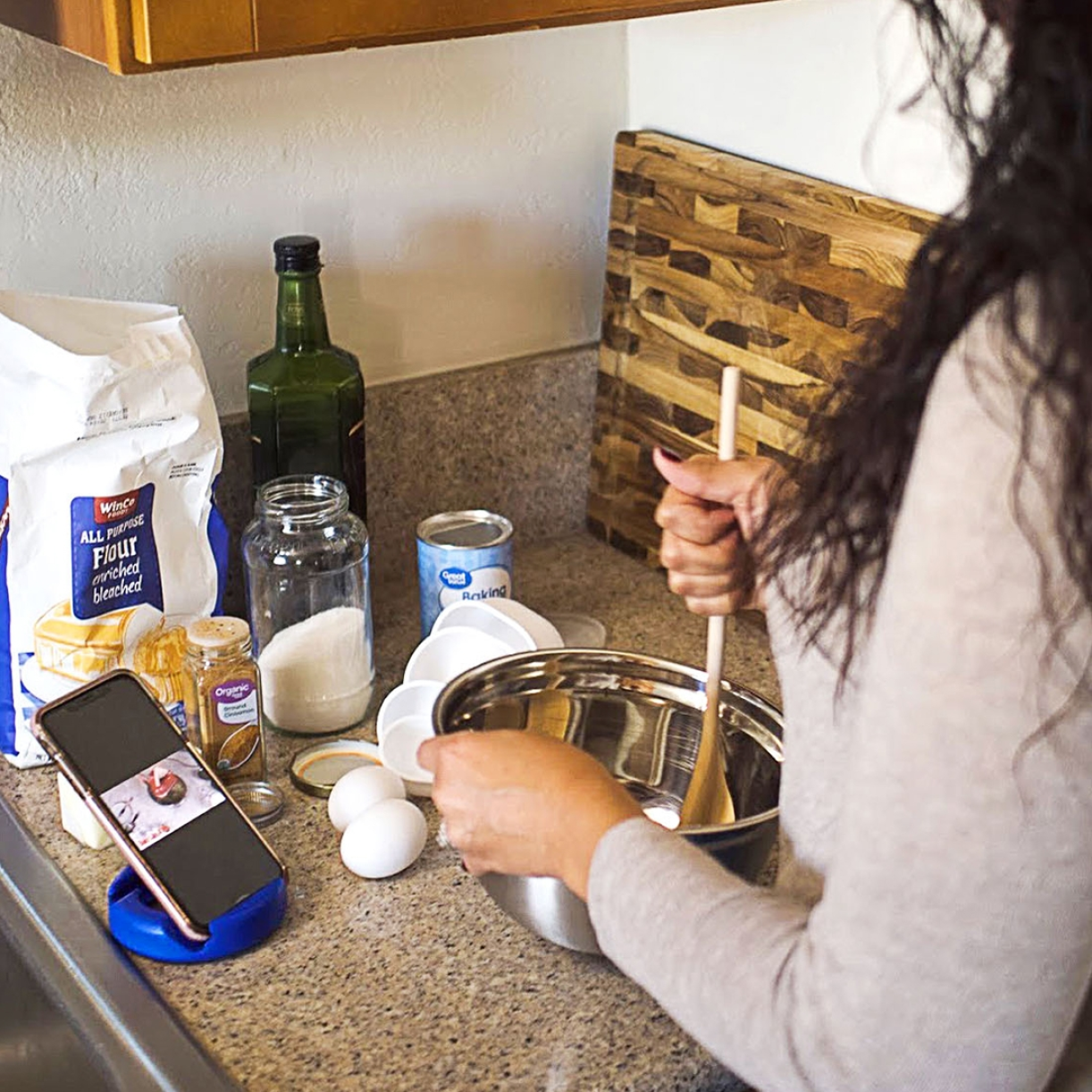 GoDonut stand holding a phone while cooking in a kitchen