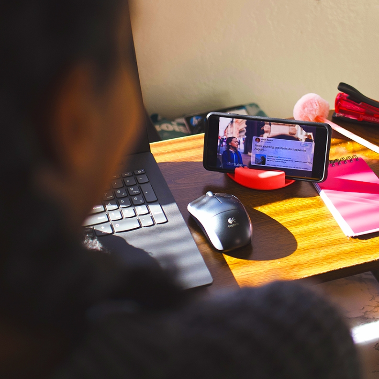 GoDonut stand holding a phone next to a laptop on a desk