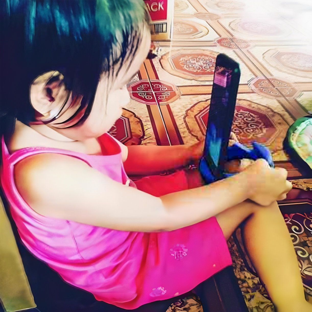 Child using GoDonut stand with a phone on the floor