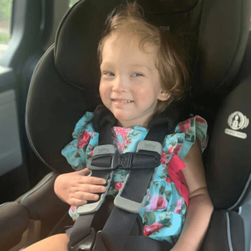 Child smiling in car seat, illustrating portability
