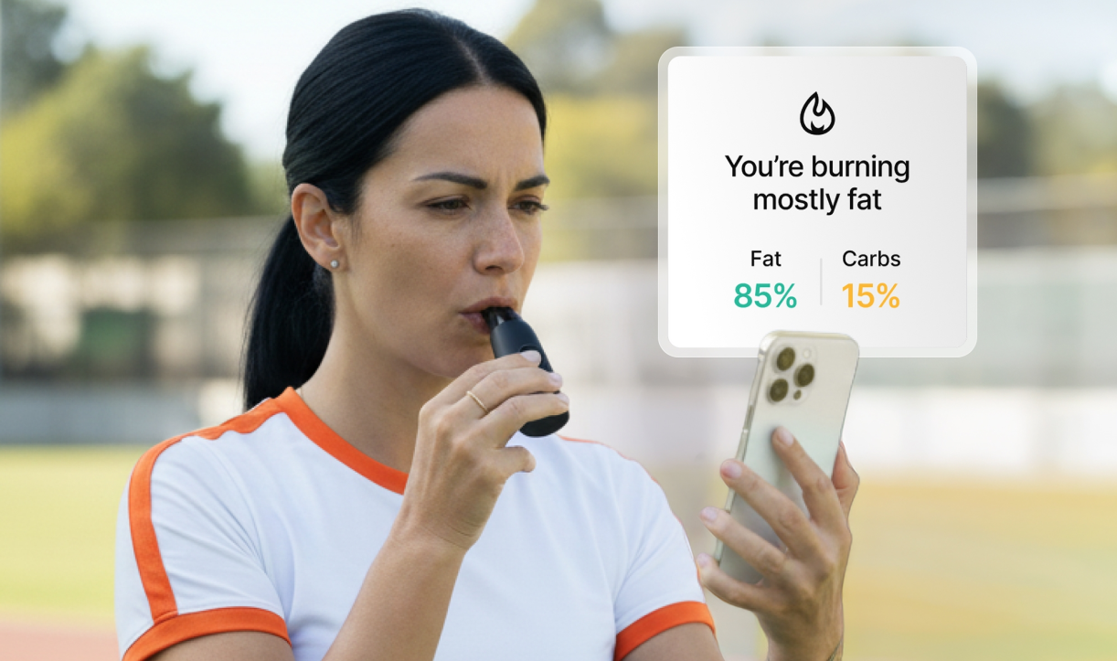 Woman using Lumen device outdoors with fat and carb burning overlay