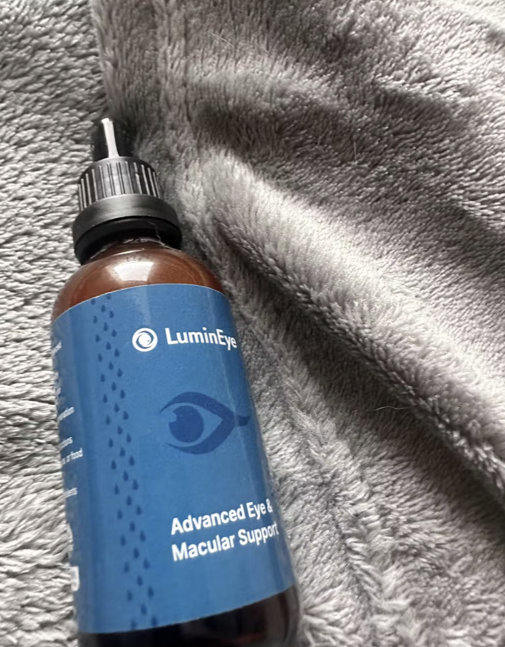 LuminEye bottle on a gray textured blanket