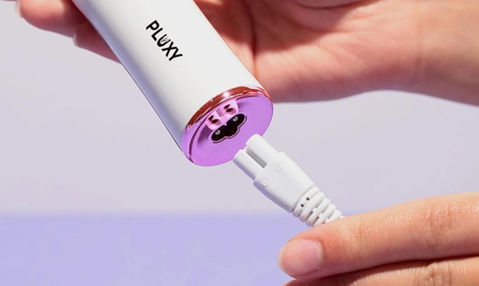 Close-up of Pluxy device being plugged in to charge