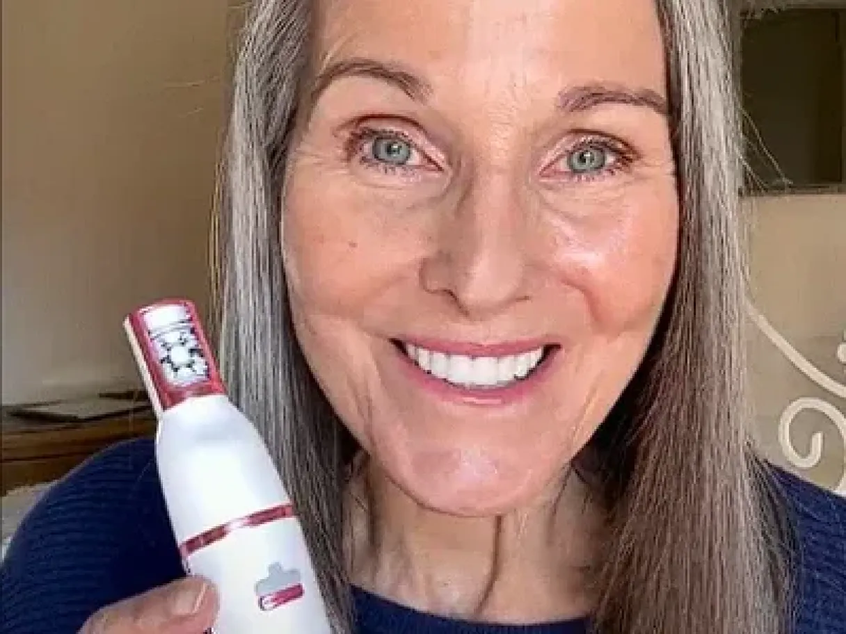 Customer smiling and holding the Pluxy device up to the camera