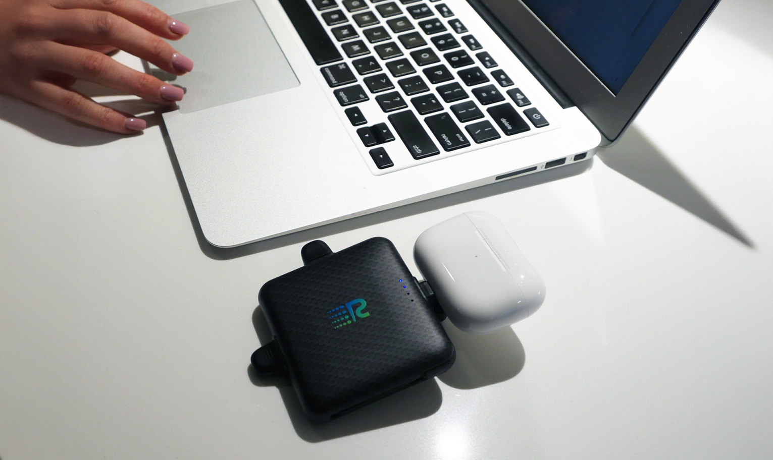Rush Charge Universe on a desk with a laptop and wireless earbuds case