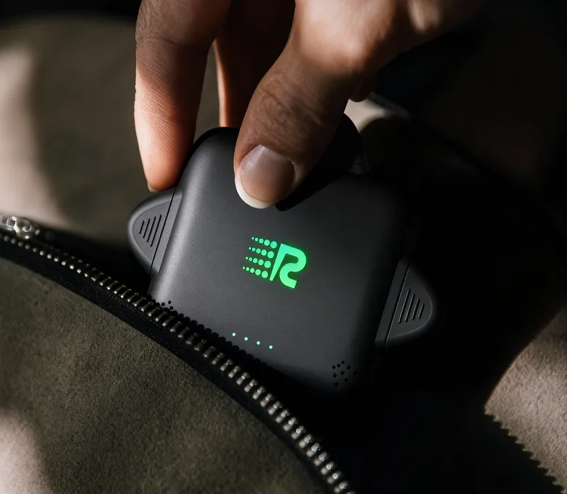 Hand placing Rush Charge Universe charger into a bag, showing portability