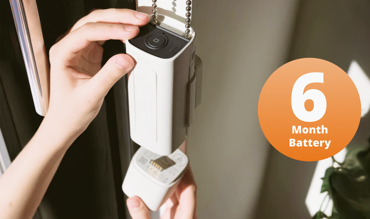 Hands installing or adjusting a window blind automation device with a '6 Month Battery' text overlay