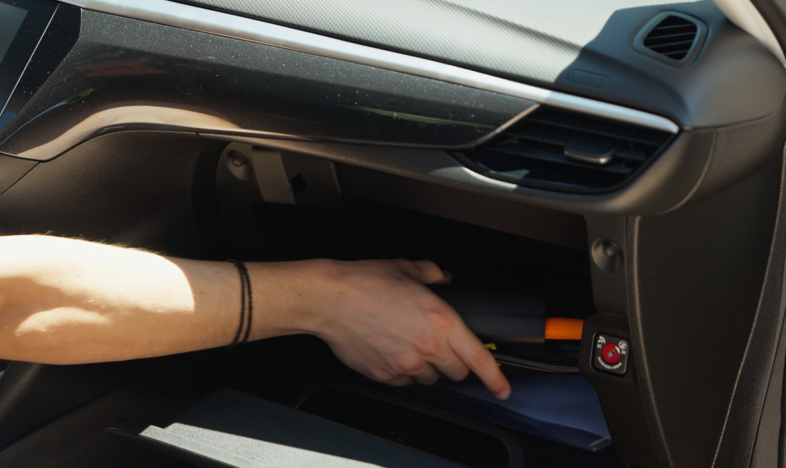 Person placing the TireHero pump into a car's glove compartment
